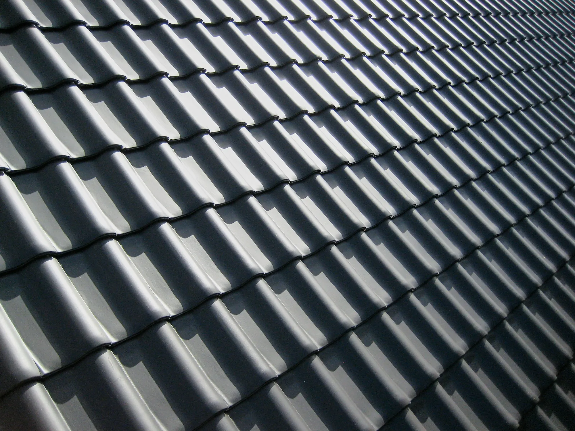 Dark gray tile-profile roof panels in a repeating pattern