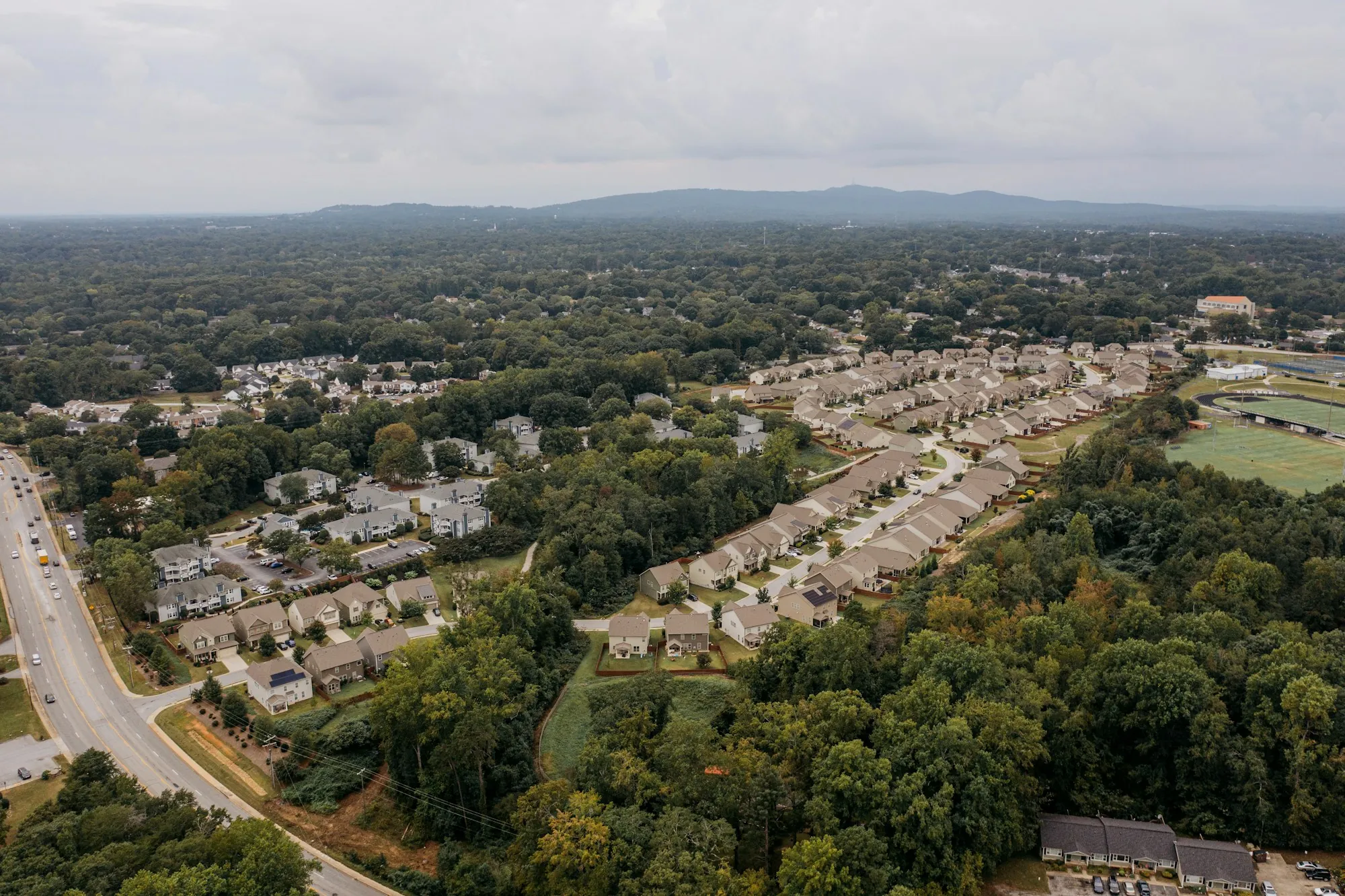 Aerial view of homes along a wooded road