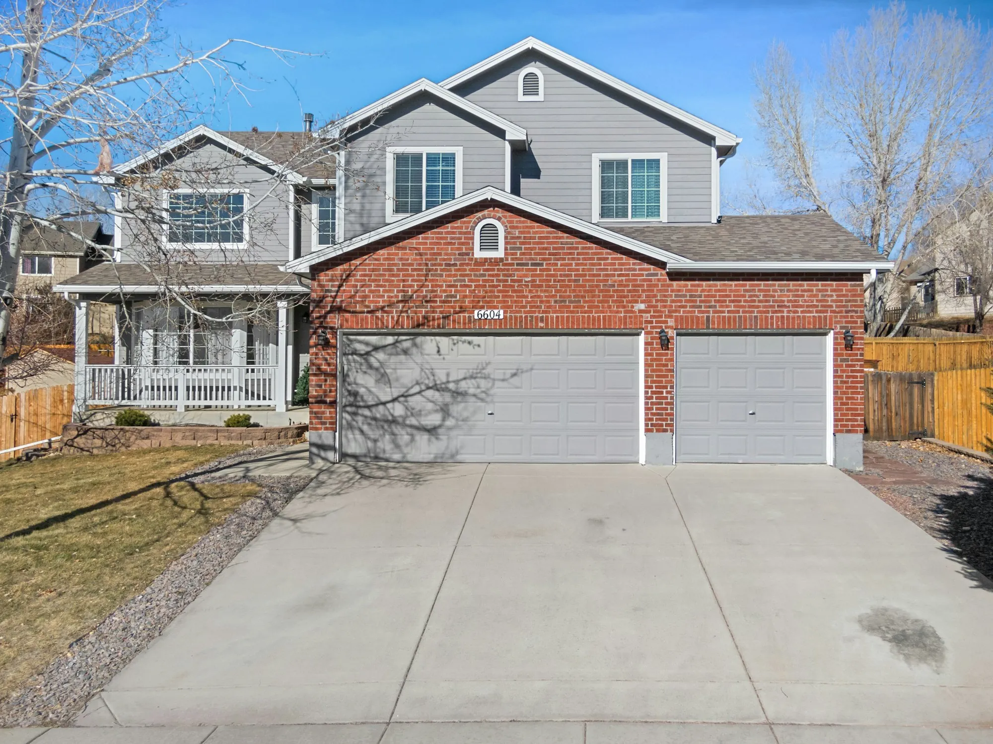 Brick two-story home with a gray shingle roof and two-car garage